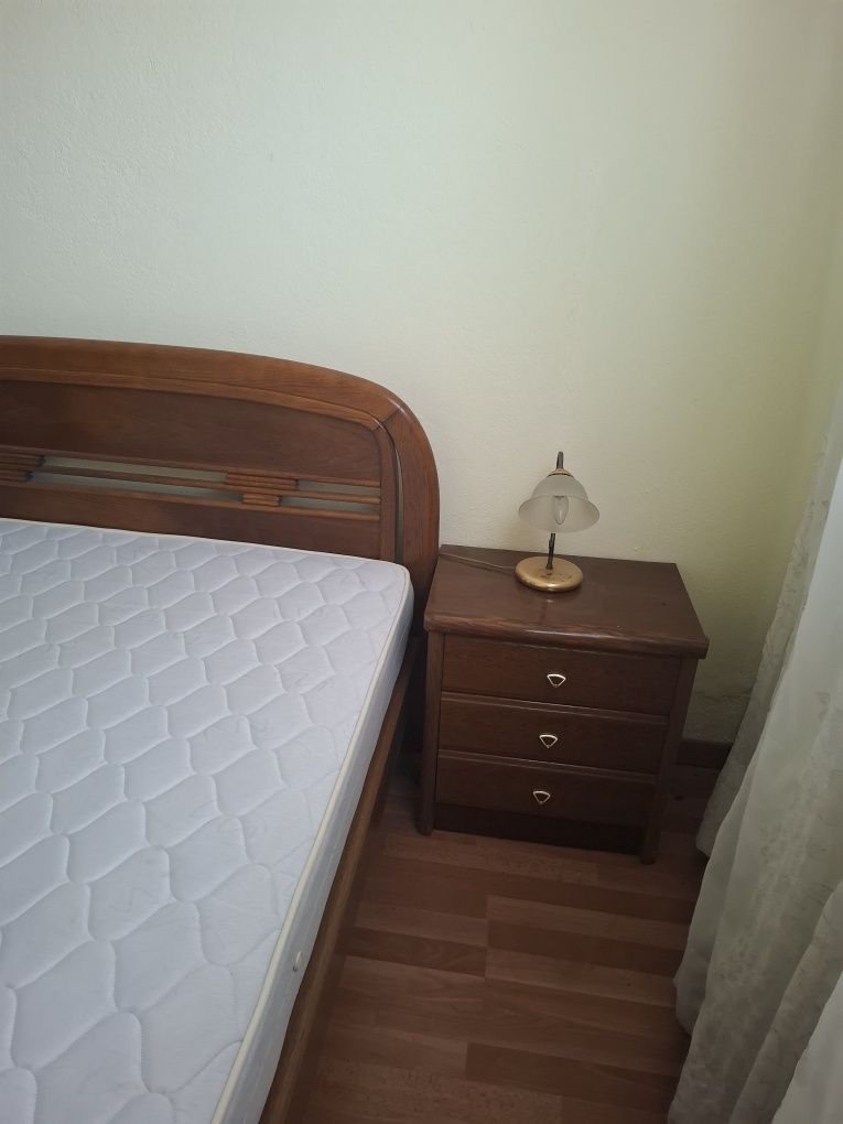 Cama com colchão e mesas de cabeceira