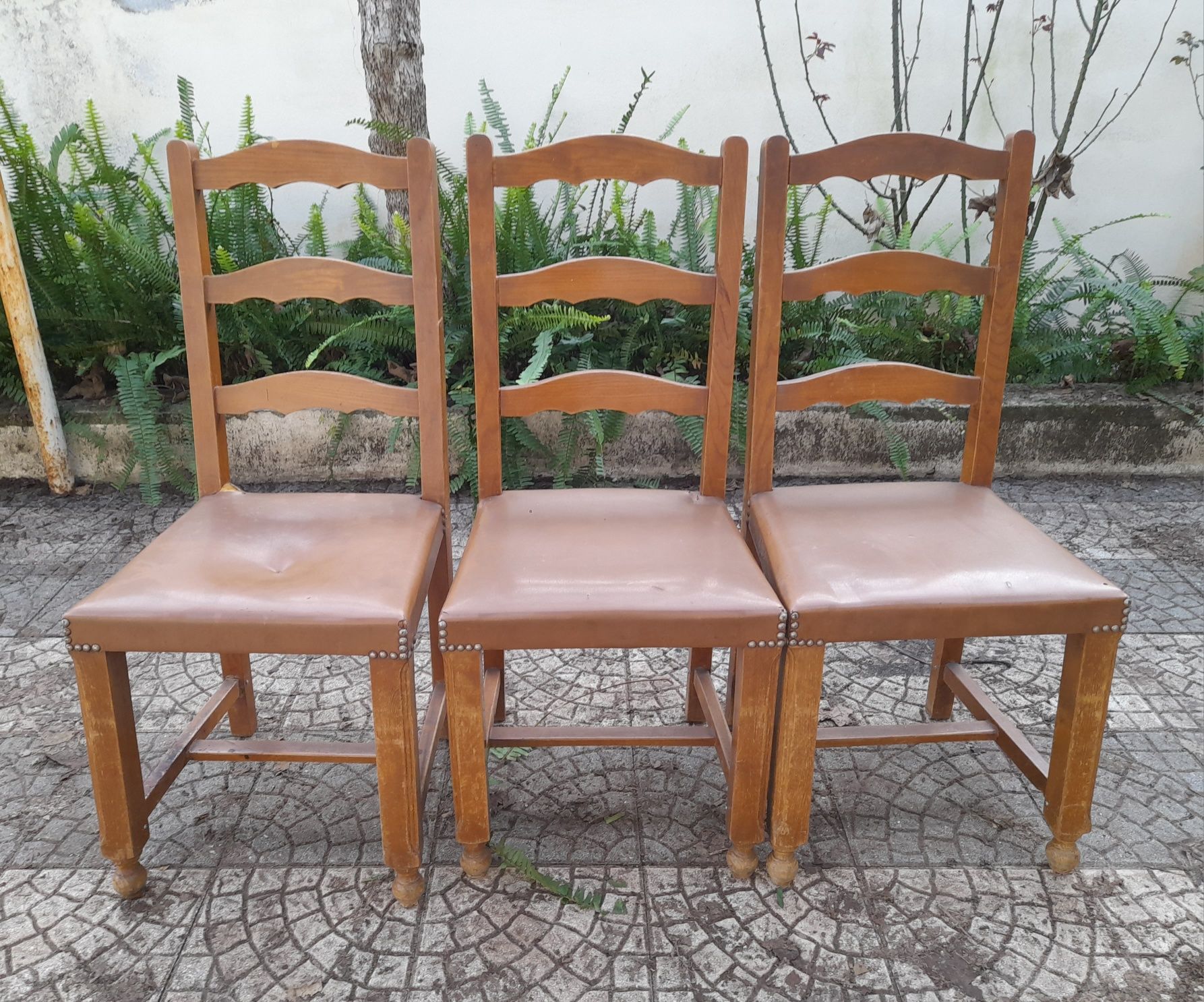 3 cadeiras de madeira e pele