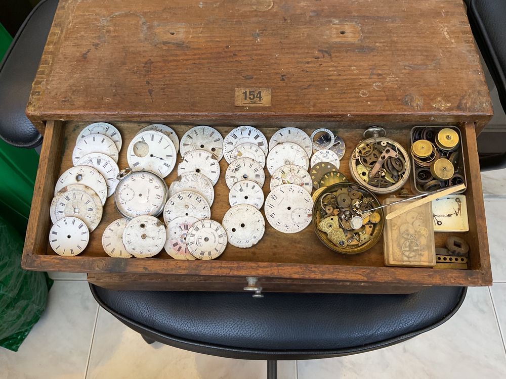 Pequeno armário com centenas de peças de relógios de bolso