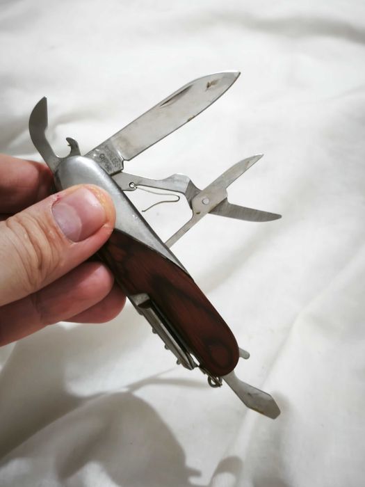 Canivete multifunções com acabamento em madeira e metal.