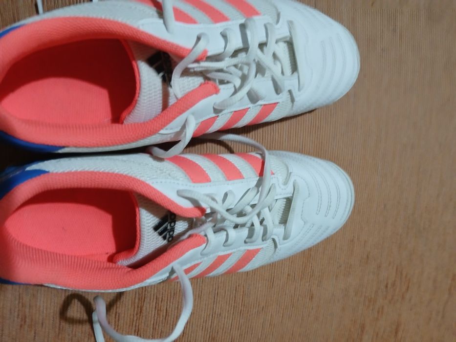 Chuteira da adidas branca e laranja