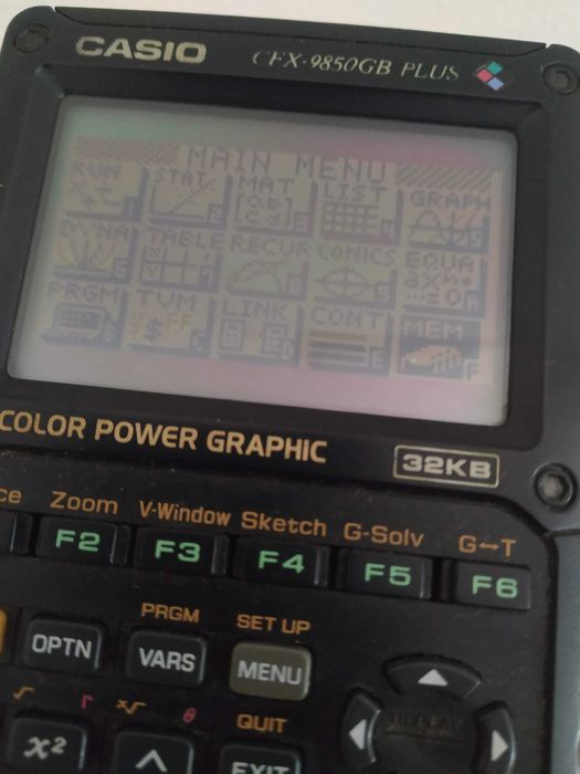 Casio CFX-9850GB Plus — calculadora gráfica, com tampa, a funcionar