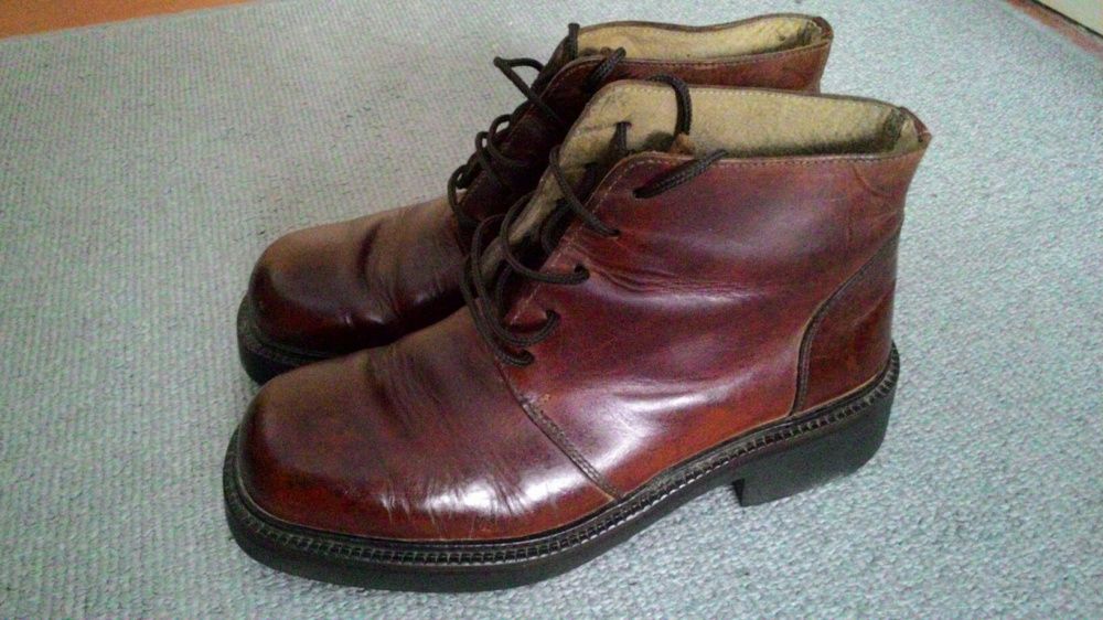 Dois pares botas em pele um pretas, outro castanhas