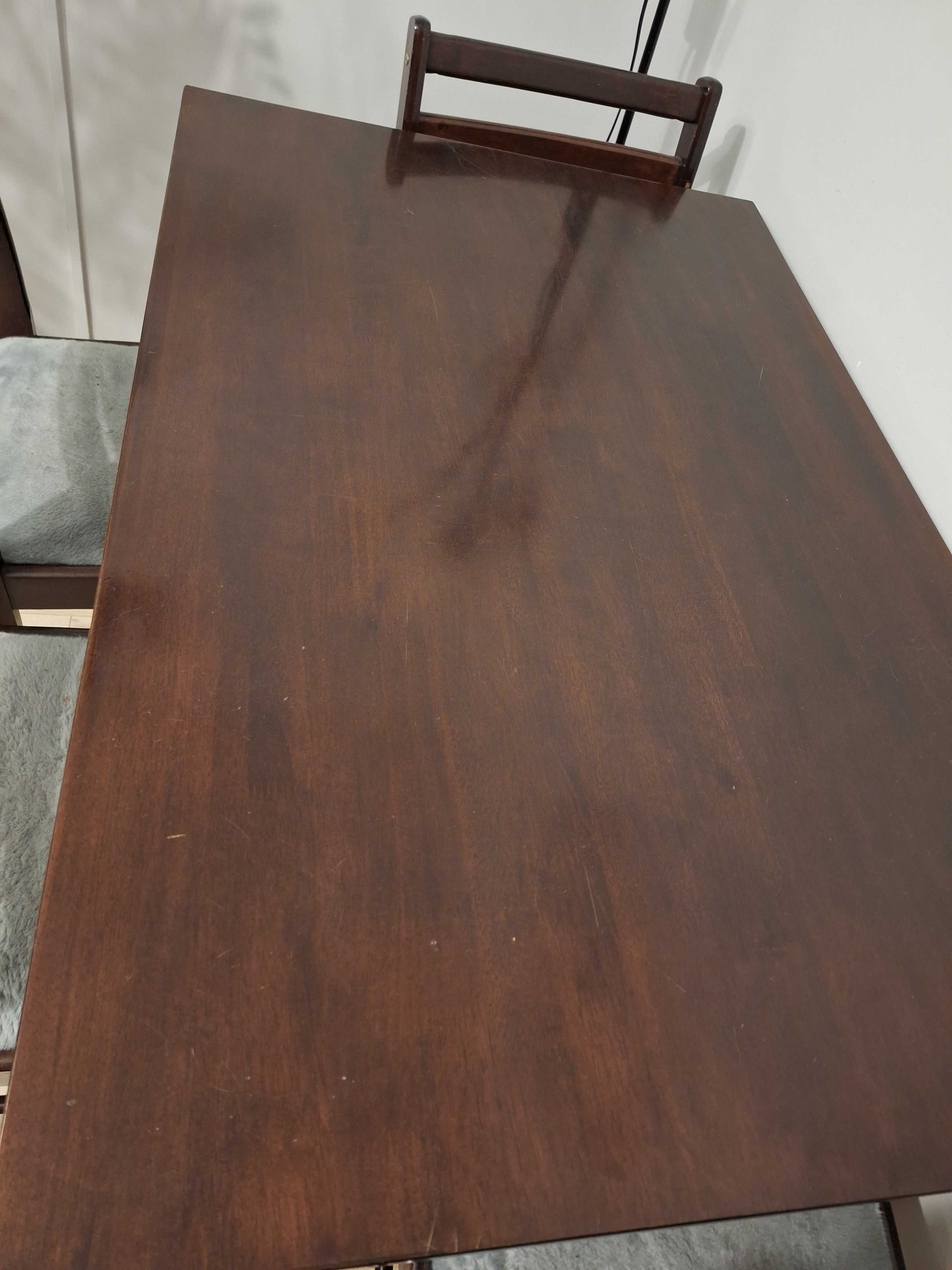 Stół drewniany, lakierowany, brązowy.