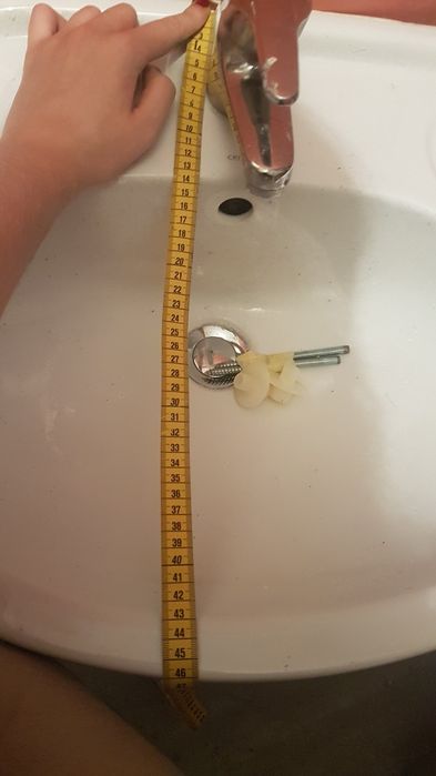 Umywalka biała z baterią i rurkami