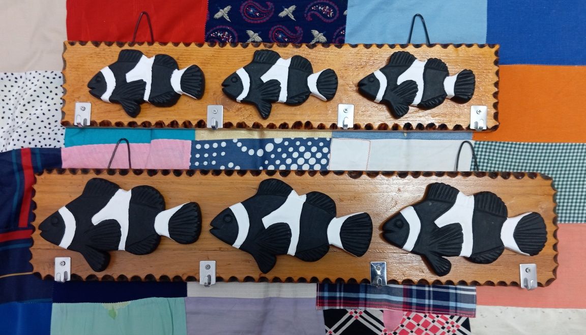 Placas decorativas em madeira com pequenos cabides.