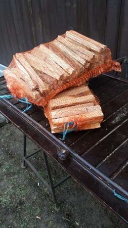Drewno rozpałkowe w workach i drewno na ognisko.