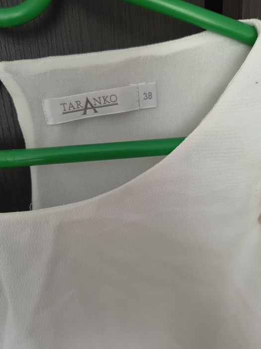 Elegancka ecru bluzka ze złotymi łańcuszkami falbany na ramionach