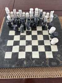 Tabuleiro em pedra com as peças xadrez e damas