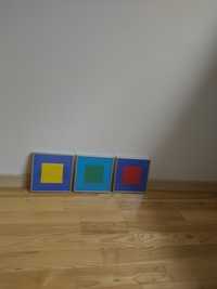 Trzy kolorowe obrazki kwadratowe w ramkach w stylu Kazimierza Malewic