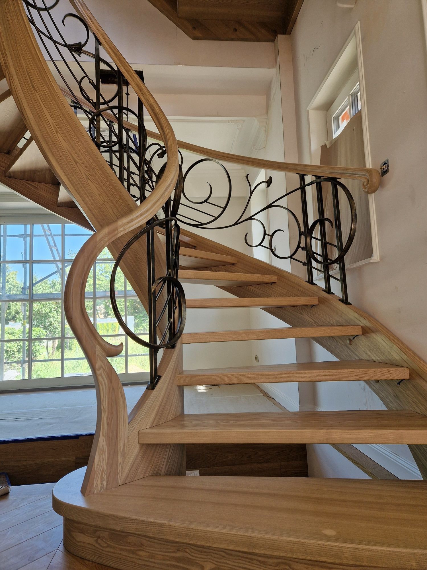 Schody gięte drewniane kręcone kute balustrady