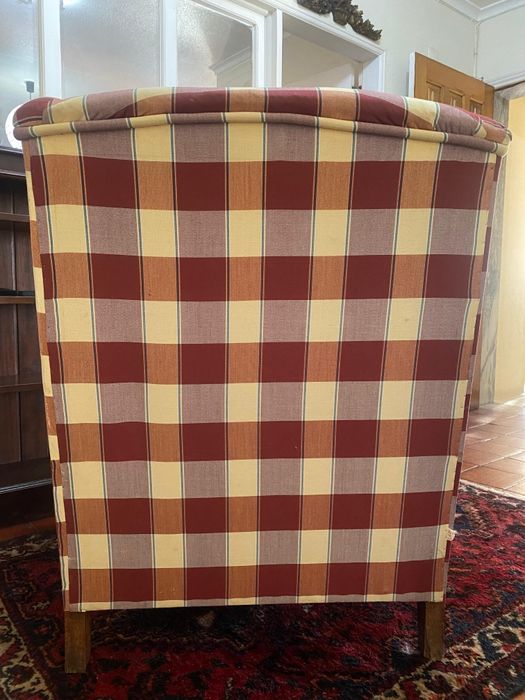 Poltrona vintage de orelhas com estampa xadrez.