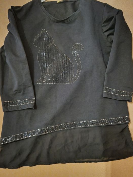 Śliczna czarna bluzka ozdobiona aplikacją w kształcie kota z cekinów.