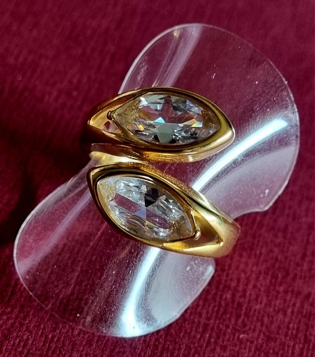 Anel dourado, em aço, com 2 pedras de vidro transparentes. T19