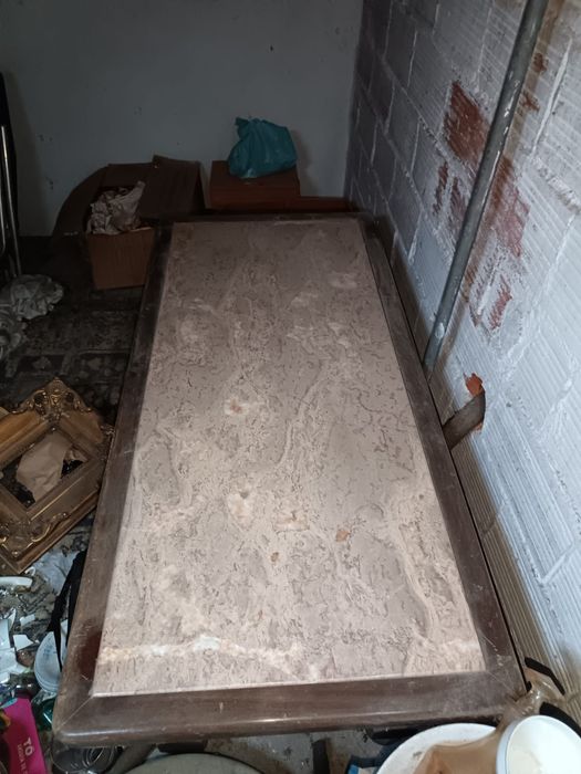 Mesa de madeira castanha com tampo de pedra muito antiga