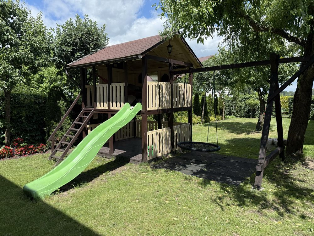 Drewniany domek dla dzieci z huśtawkami, gniazdem i zjeżdżalnią wodną
