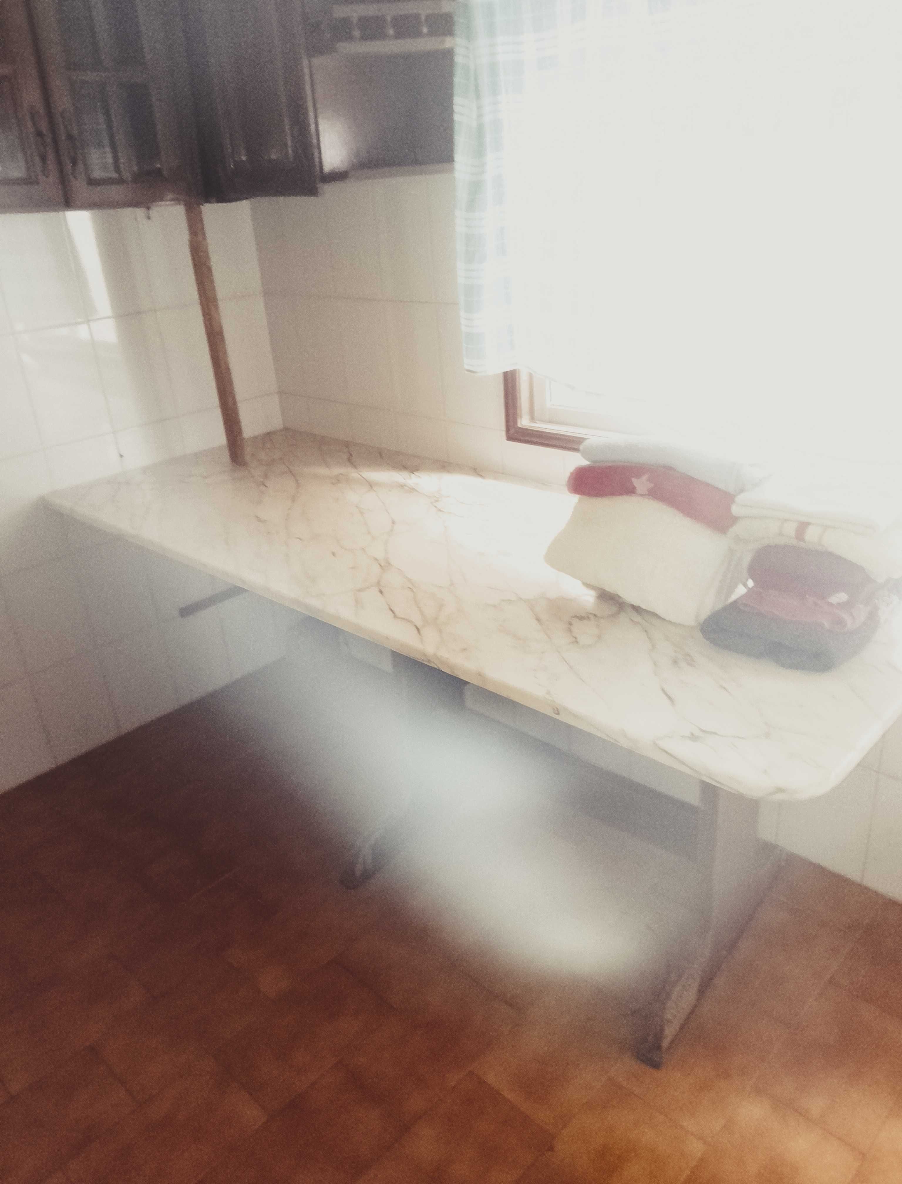 Cama, sofá e mesa de cozinha em pedra