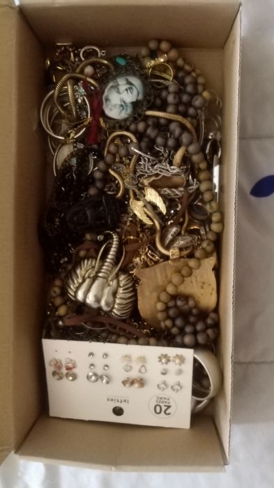 Caixa com jóias, colares, anéis, pulseiras, pingentes de colares e bri