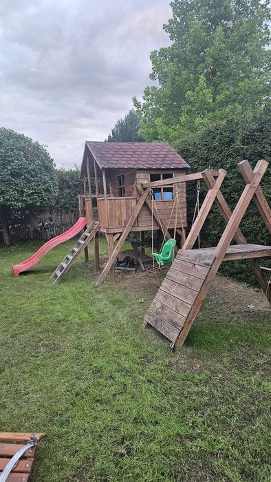 Domek dla dzieci z tarasem zjeżdżalnią huśtawkami  ścianką wspinaczkow