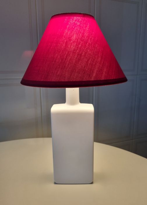 Candeeiro de mesa, feito com uma garrafa branca e abajour vermelho.