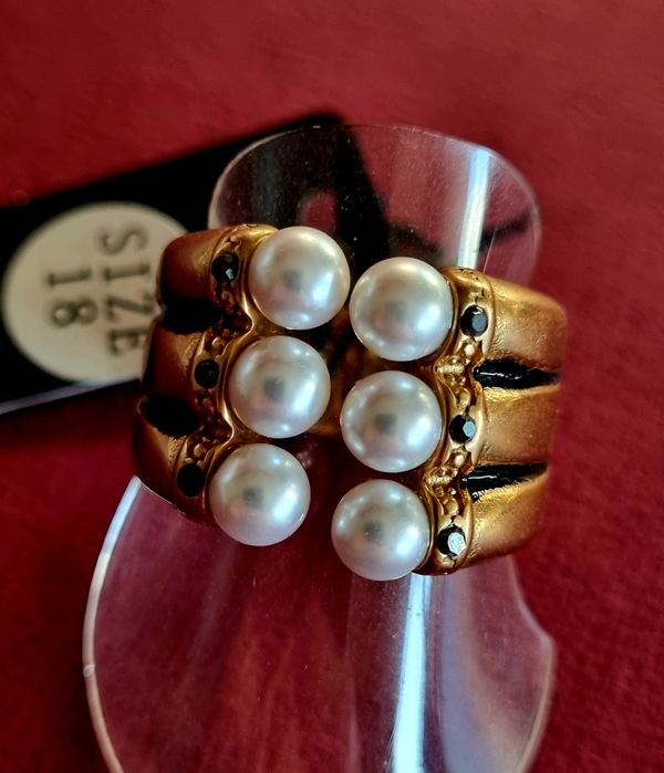 Anel dourado e preto, em aço, com 6 pérolas e 6 pedrinhas pretas. T18