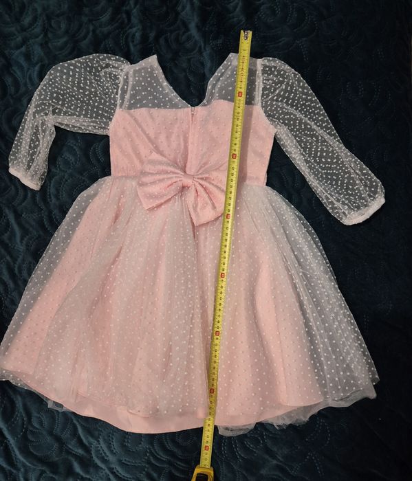 Piękna sukienka bladoróżowa z przezroczystymi rękawami i kokardą