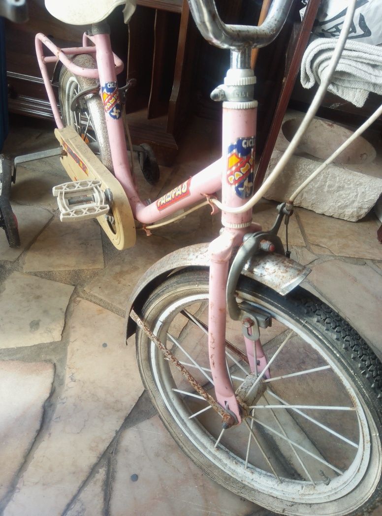 Duas bicicletas antigas de criança a precisar de arranjo
