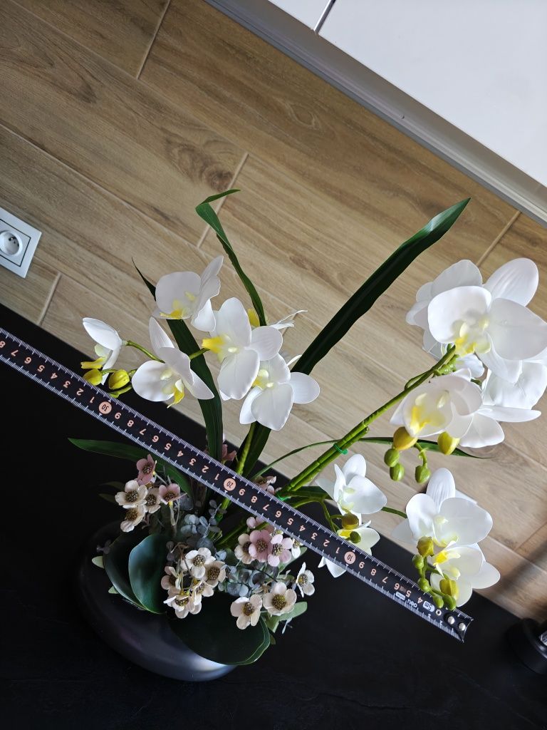 Sztuczny storczyk orchidea w czarnej ceramicznej doniczce