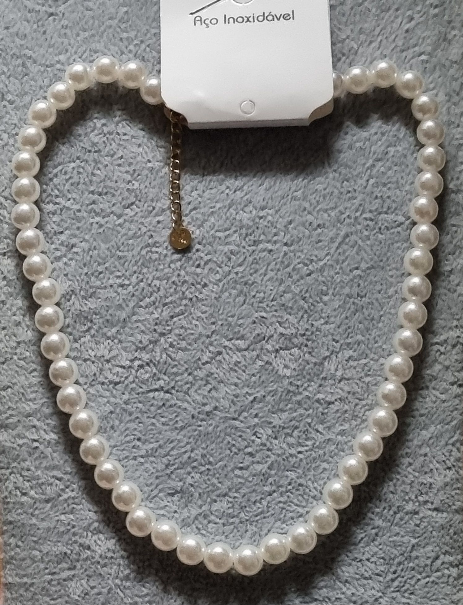 Colar/choker de pérolas com acabamento dourado em açol. Tem extensor