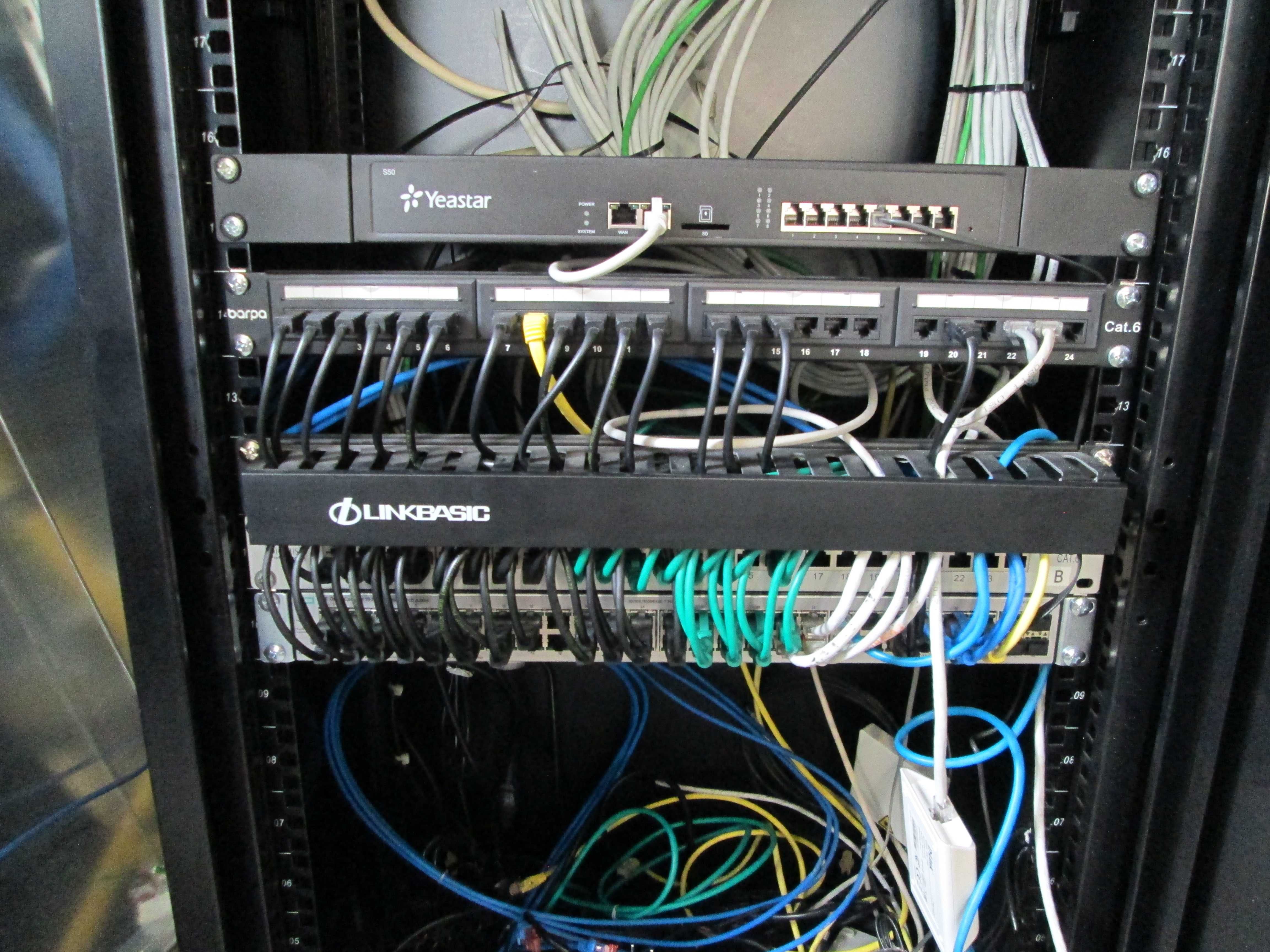 Bastidor de rede informática com diversos componentes.