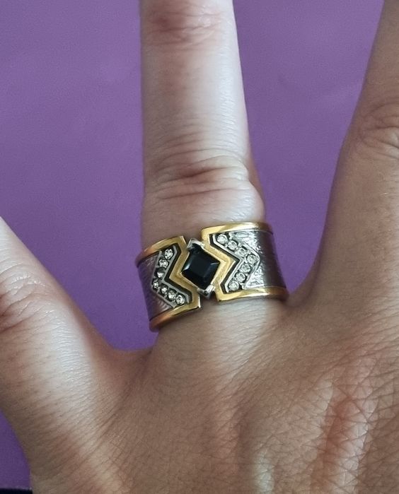 Anel bicolor, em aço, com zirconias e uma pedrinha preta. Só T20