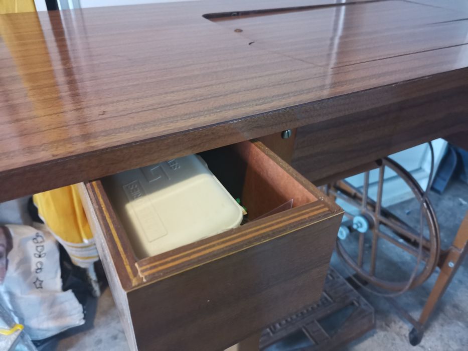 Máquina de costura a trabalhar com móvel com gavetas