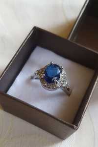 Elegancki, widoczny pierścionek w kolorze srebra z niebieskim oczkiem