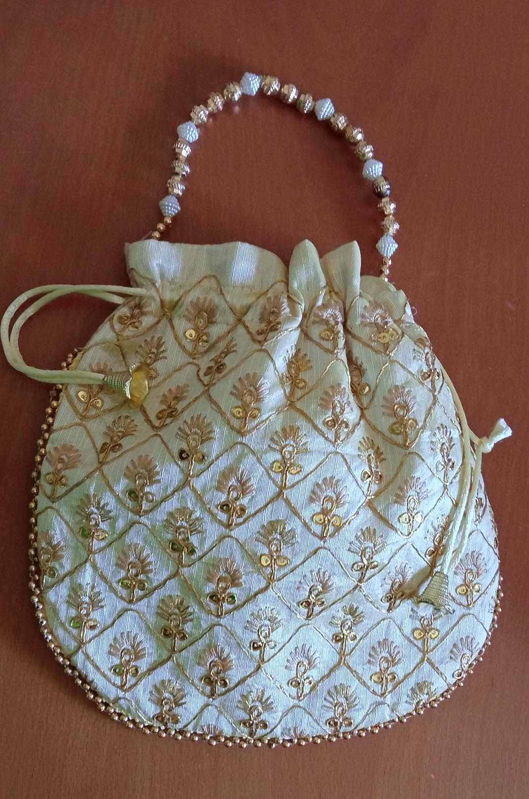 Bolsa de mão branca com bordado dourado