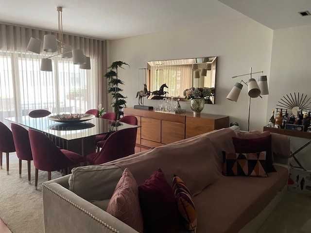 Sofá em veludo, debruado com tachas prateadas.