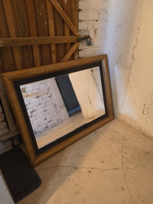 Duże lustro w złotej ramie.