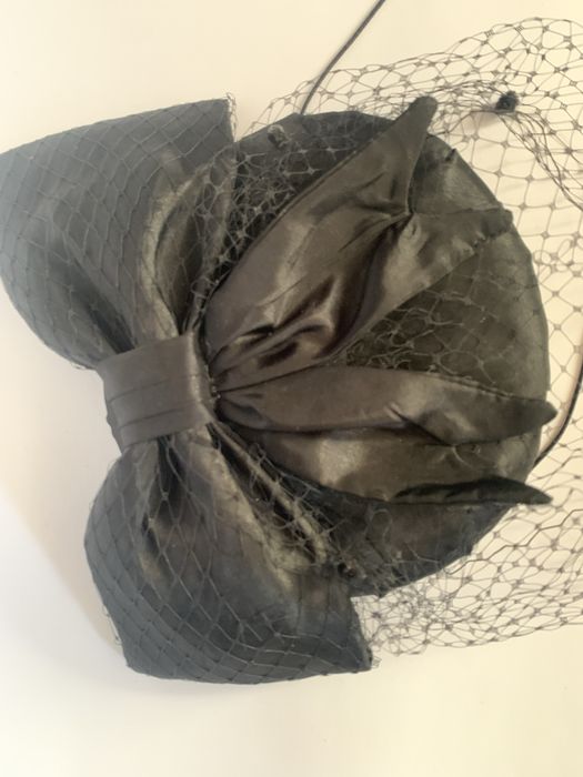 Чорний капелюшок-таблетка з вуаллю та бантом.