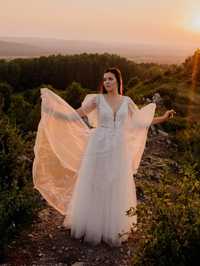 Biała błyszcząca z koronką suknia ślubna z motylkowymi rękawami