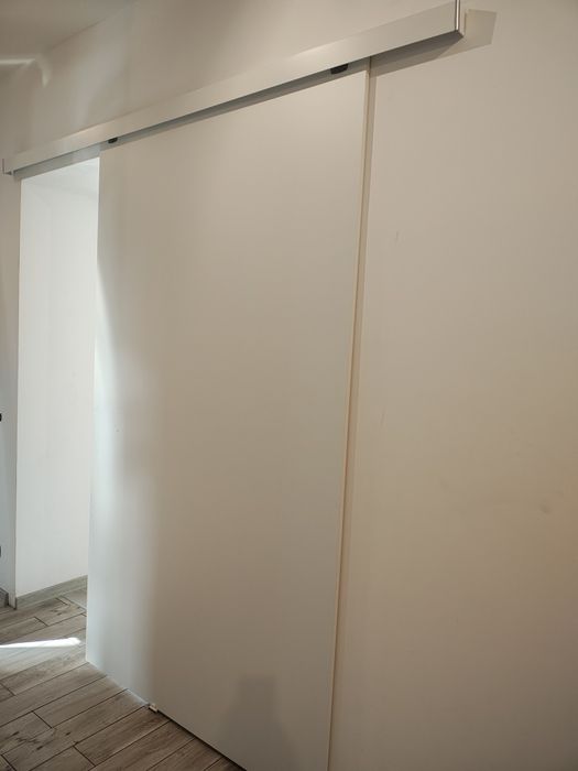 Solidne drzwi przesuwne białe wewnętrzne z systemem mocowania do ścian