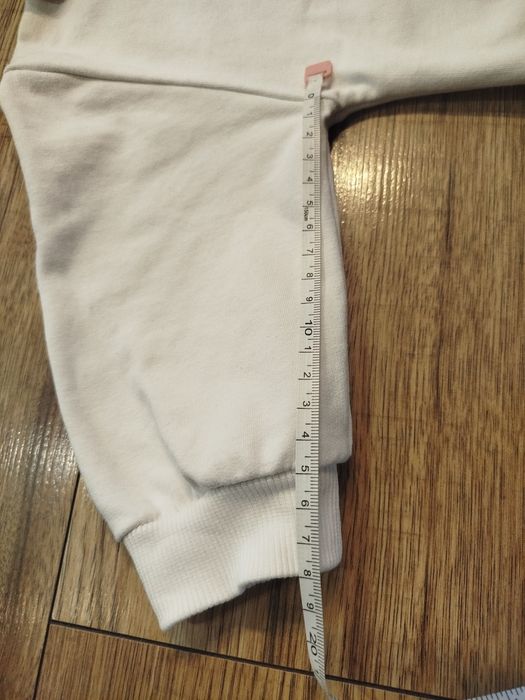 Biała bluza bawełna 80 86 z ozdobną odpinaną dekoracja na dekolcie.