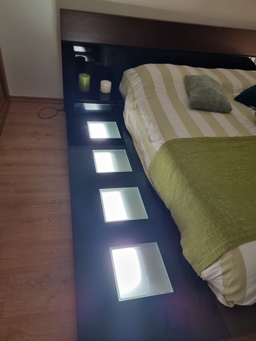 Cama de casal com mesa cabeceira e luz lateral