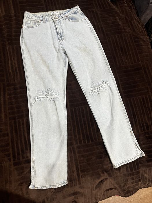 Світлі блакитні джинси з рваними колінами