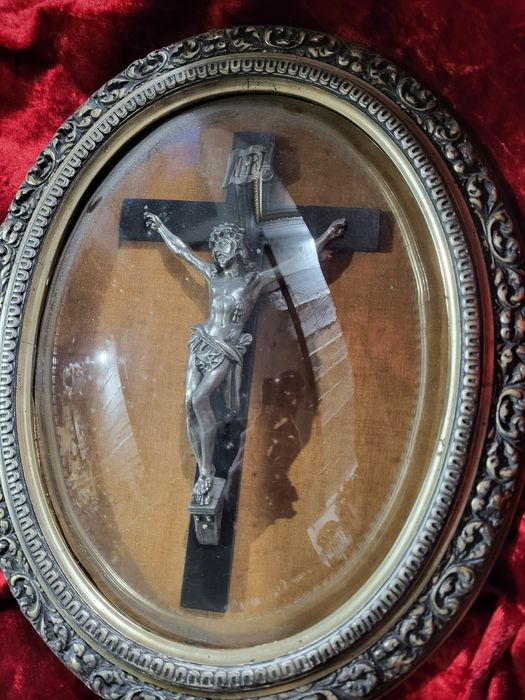 Stary krzyż w owalnej ramie za szkłem