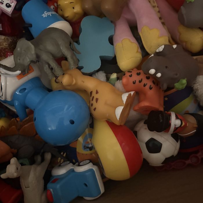 На изображении показана коробка, наполненная разнообразными игрушками.