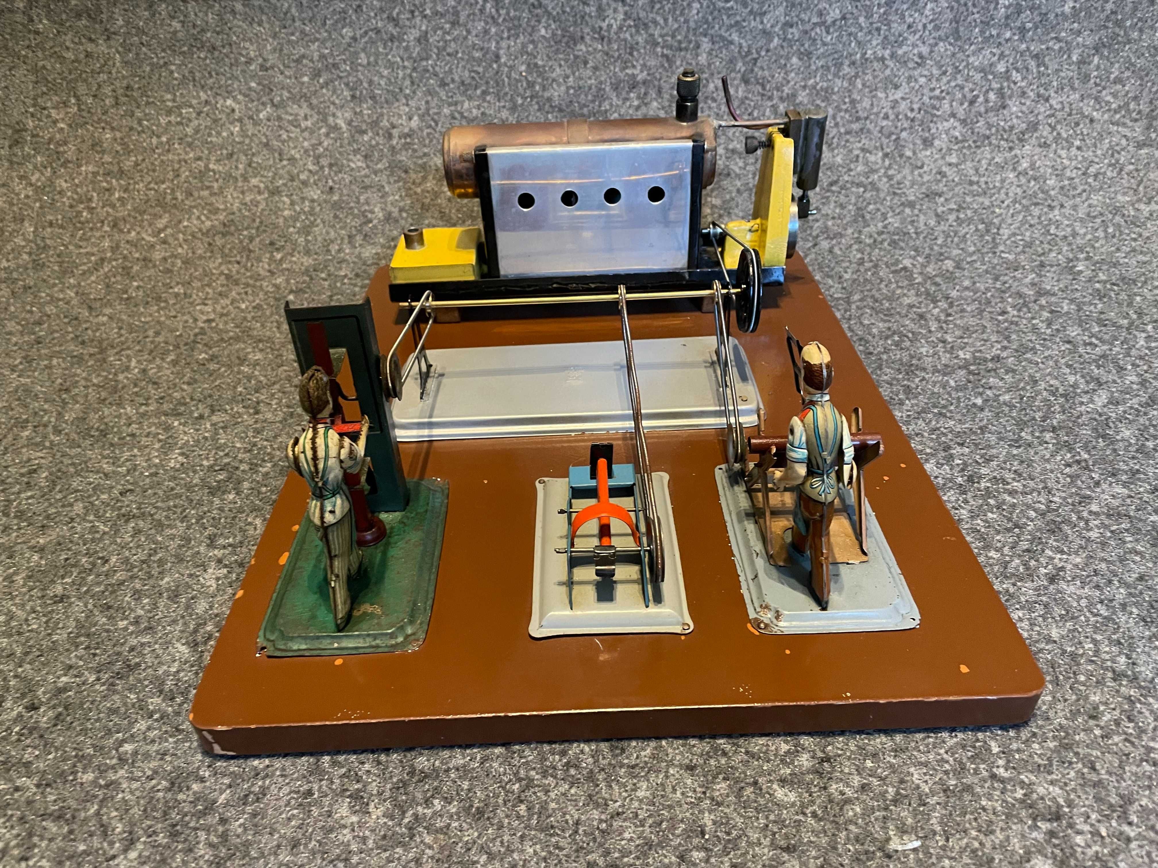 Brinquedo técnico antigo a vapor com bonecos em chapa