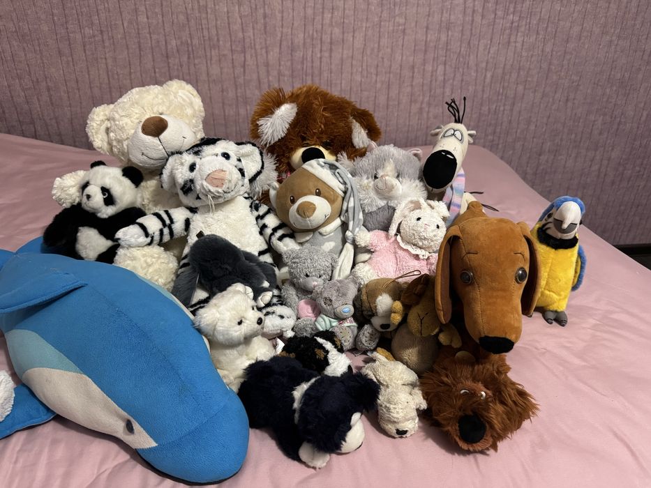 Багато різних дитячих мʼяких іграшок дельфін ведмідь собака панда тигр
