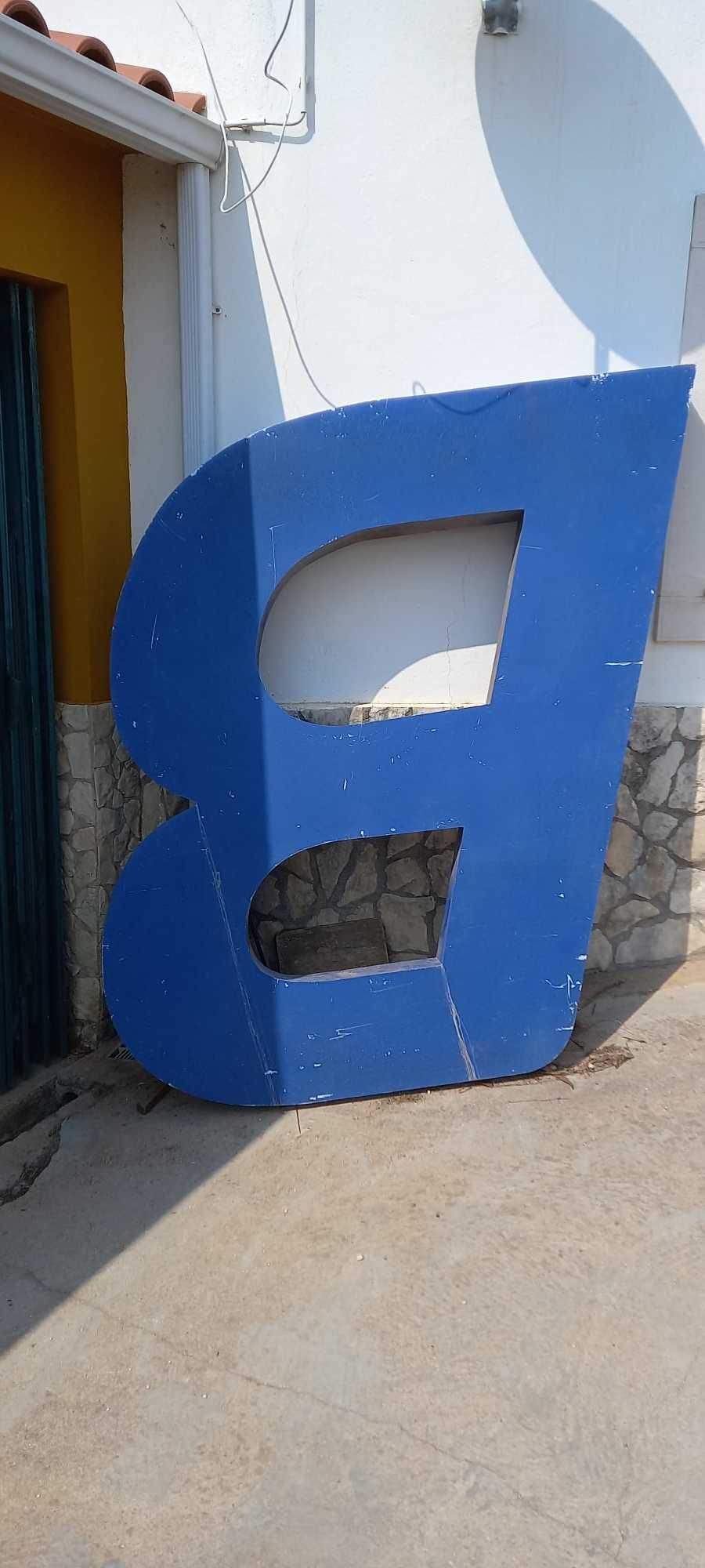 Peça metálica com o formato da letra B. Tamanho grande.