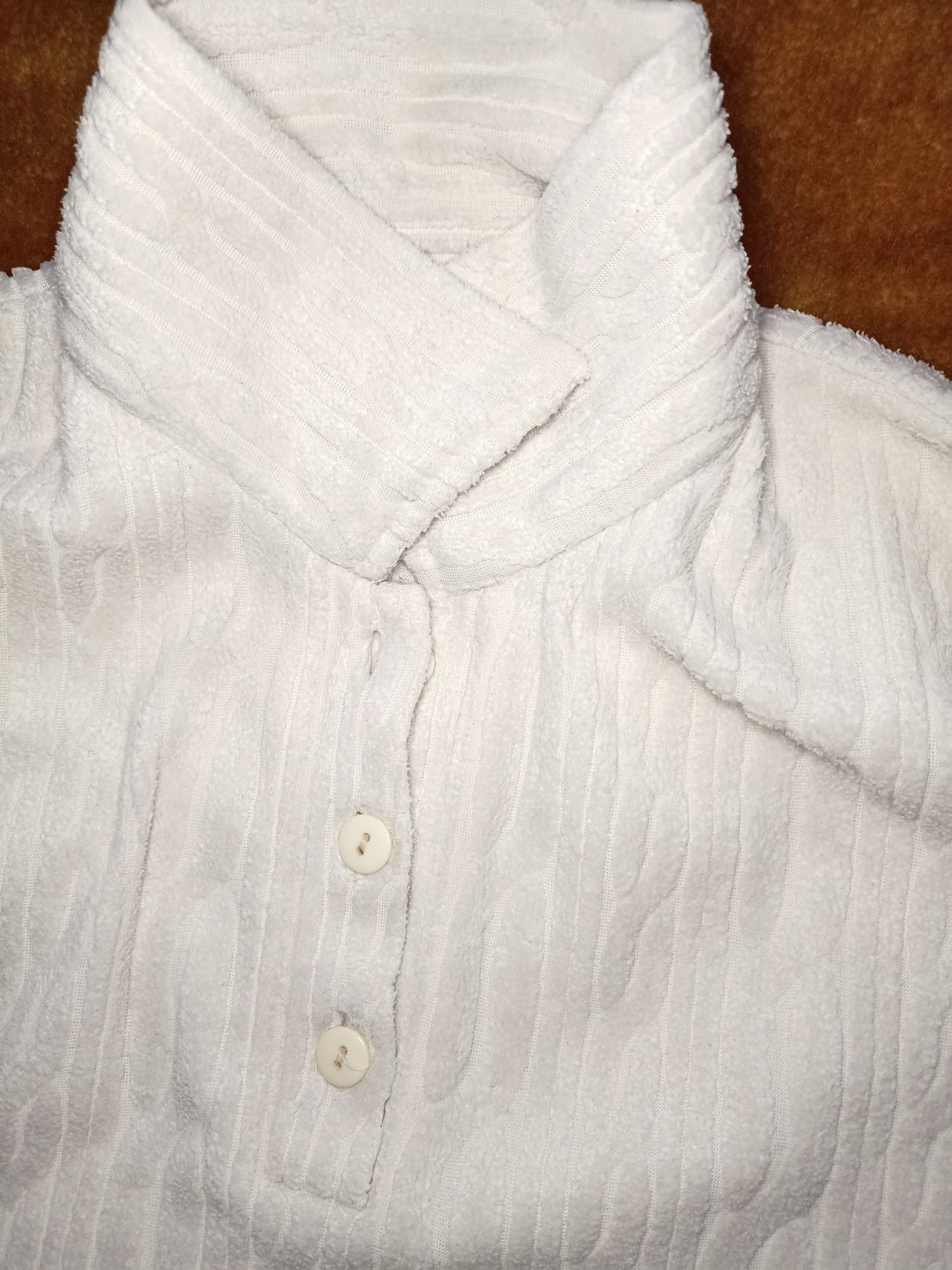 Biały sweter zakładany przez głowę