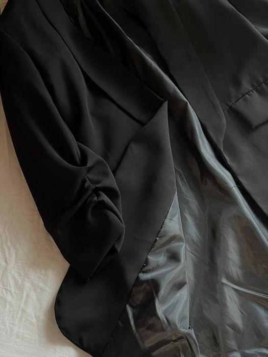 Елегантний подовжений чорний піджак.