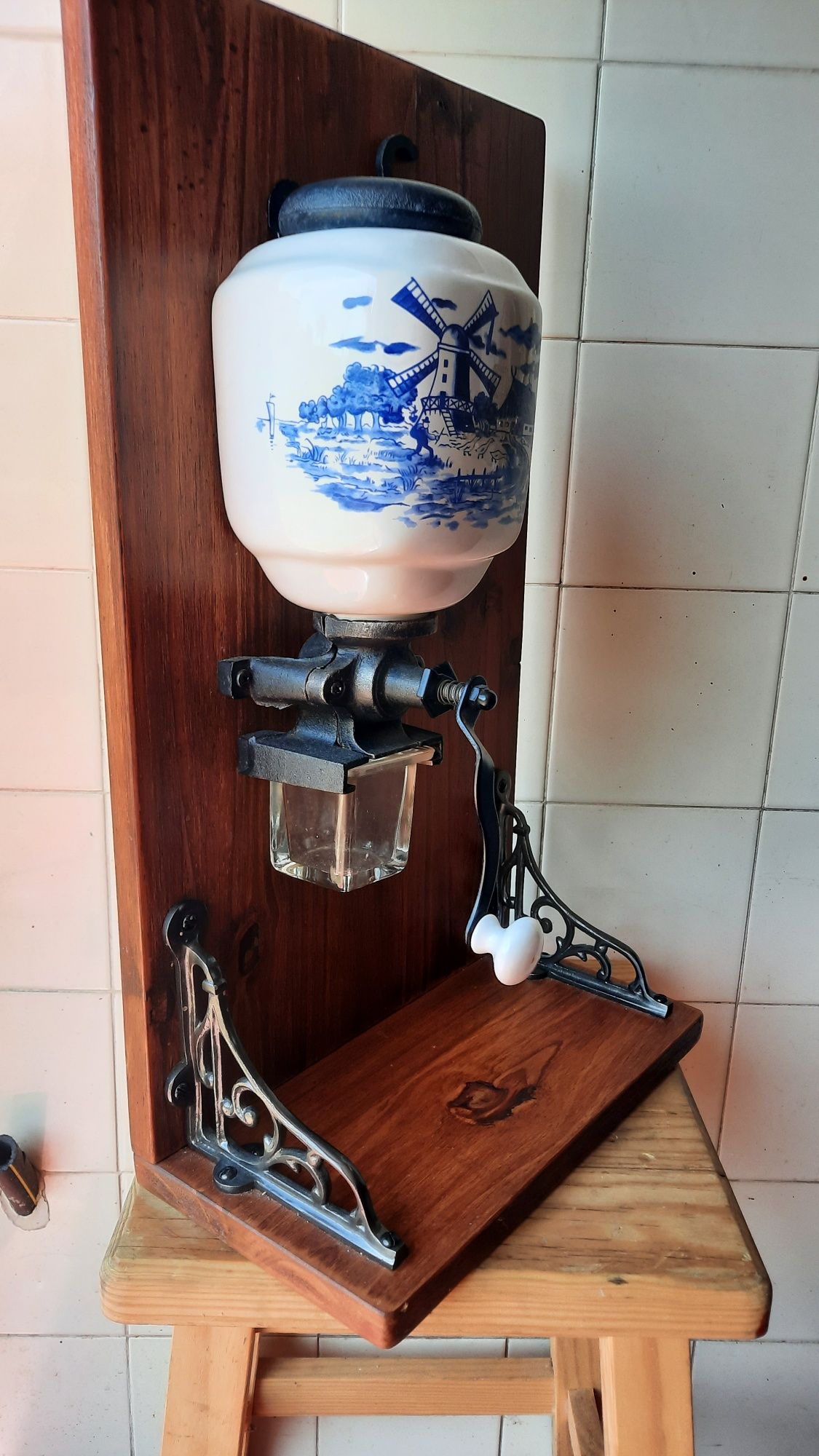 Moinho manual de café com suporte em madeira.